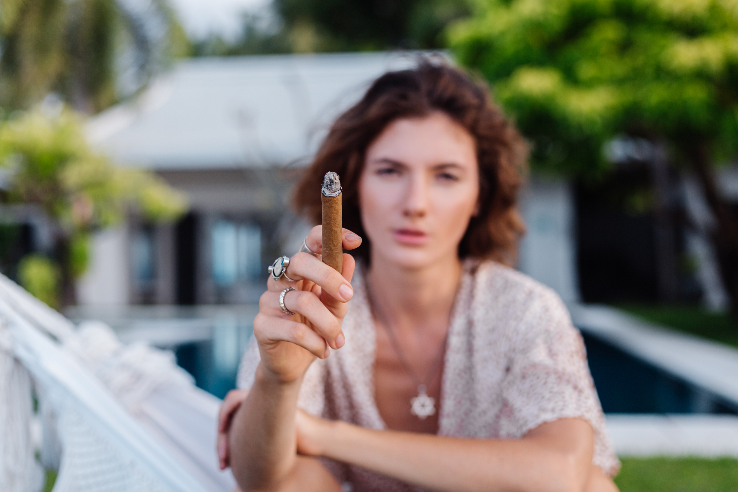 Donna che fuma un sigaro sdraiata su un'amaca
