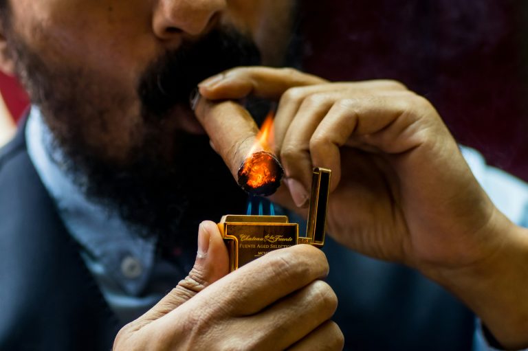 Uomo che accende un sigaro con l'accendino